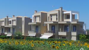 a row of houses with a field of sunflowers at Niovi Boutique Apartments in Afitos