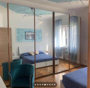 1 dormitorio con cama azul y espejo en SoleMare Rooms Trieste en Trieste