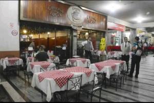 um restaurante com mesas e pessoas de pé na frente dele em Seu Lugar em Beagá em Belo Horizonte