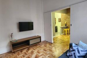 uma sala de estar com uma televisão de ecrã plano na parede em Seu Lugar em Beagá em Belo Horizonte
