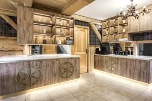 a kitchen with wooden cabinets and a kitchen island at Dworek pod Giewontem in Kościelisko