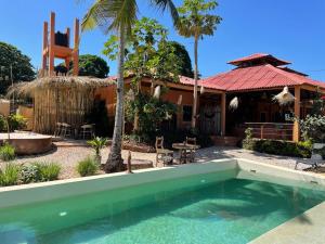 uma casa com piscina em frente a uma casa em CAJOU LODGE em Bubaque