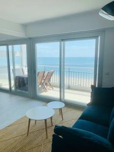 uma sala de estar com um sofá e vista para o oceano em Vue mer Appartement Le Miramar em La Baule