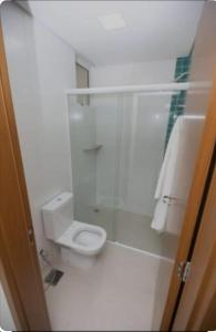 a bathroom with a toilet and a glass shower at Alta Vista Thermas Resort Torre 2, Apartamento 201 in Caldas Novas