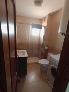 a bathroom with a toilet and a sink and a washing machine at Atiko Welcome in Arcos de la Frontera