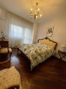 1 dormitorio con cama y lámpara de araña en Stanza classica Eur Tintoretto, en Roma