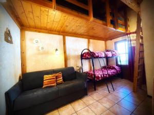 ein Wohnzimmer mit einem Sofa und einem Etagenbett in der Unterkunft Residence Trompe-L'oeil in Champoluc