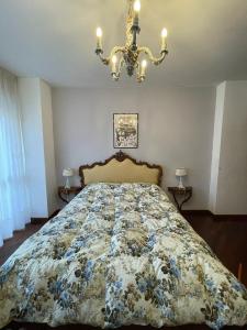 a bed in a bedroom with a chandelier at Stanza classica Eur Tintoretto in Rome