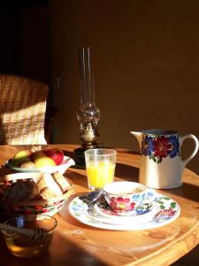 una mesa con un bol de fruta y una taza de zumo en Chez Cathy, en Arzier