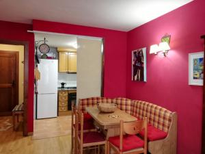 a kitchen with red walls and a table and chairs at Magic Pirineos in Anciles