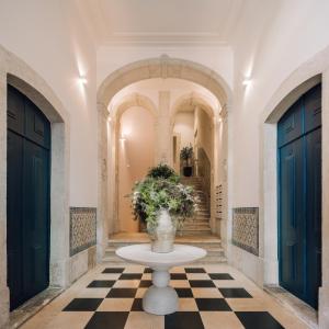 einen Flur mit zwei blauen Türen und einem Tisch mit einer Pflanze in der Unterkunft Ando Living - Madalena Townhouse in Lissabon