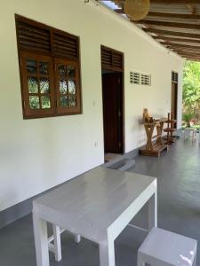a white bench in a room with a table and chairs at Original track by Unrushed in Weligama