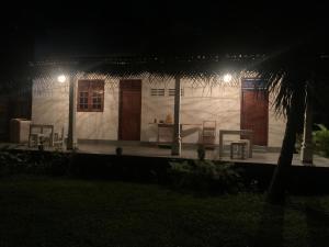 a white house at night with a table and chairs at Original track by Unrushed in Weligama