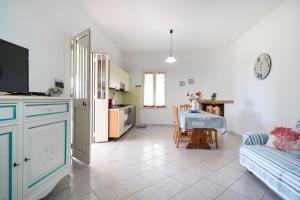 een keuken en woonkamer met een tafel en een bank bij Villa Sa Mela 28 in Orosei