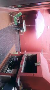 a red wall with an open box with an umbrella at Posada the secret in Colonia del Sacramento