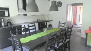 eine Küche mit einem schwarzen Tisch und Stühlen sowie eine Küche mit einem Herd in der Unterkunft Metsäniityn Tuvat in Billnäs