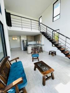 uma sala de estar com uma escada e um sofá azul em CASA LUCE DI CIELO em Tinjacá