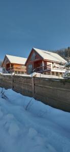 a house in the snow in front of a house at Nad Cicha -Domki caloroczne w gorach in Ujsoły