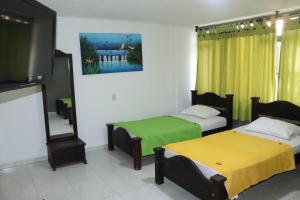 比亞維森西奧的住宿－Hotel Inambu，客房设有两张床和一台平面电视。