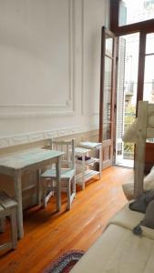 Cette chambre blanche dispose d'une table, de bancs et d'une fenêtre. dans l'établissement Dante y compañia, à Buenos Aires