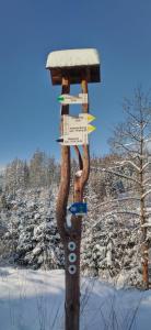a sign on a wooden pole in the snow at Nad Cicha in Ujsoły