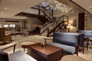 a lobby with chairs and tables and a staircase at Glasgow Grosvenor Hotel in Glasgow