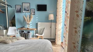 a bedroom with blue walls and a bed and a chair at APARTAMENTY Adamcykówka blisko Velo Czorsztyn, Velo Dunajec ! Jacuzzi i Sauna w cenie! in Kluszkowce