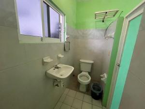 a bathroom with a toilet and a sink and a window at Posada Isis in Catemaco