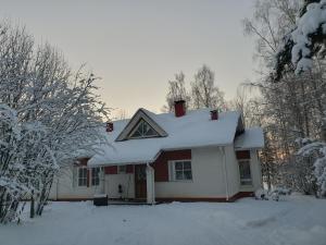 a house with snow on the roof at Lakeside Salmi in Rovaniemi