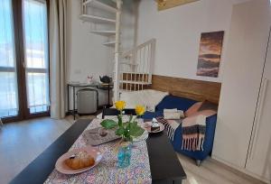 a living room with a table and a blue couch at Bed & Breakfast Le Due G in Varese