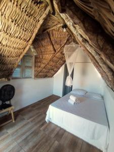 a bedroom with a bed and a chair in a attic at DuMangue Kite House in Guriú