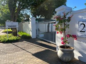 una cerca blanca con una maceta al lado en VIilla Vredenrust Guesthouse, en Bloemfontein
