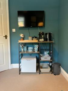 a room with a shelf with a television on a wall at ROSEWOOD in Yoxford