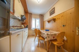 a kitchen with a table and chairs in a kitchen at Maison Ostaria MyHolidayLivigno in Livigno