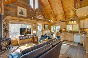 a living room with a large couch and a kitchen at Cozy Easton Cabin on the Yakima River! in Pine Glen