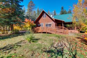 a log home with a large porch and a deck at Cozy Easton Cabin on the Yakima River! in Pine Glen