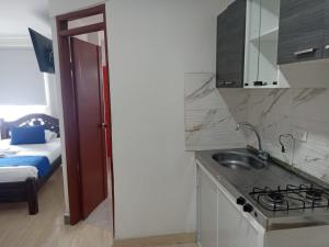 eine Küche mit einem Waschbecken und ein Bett in einem Zimmer in der Unterkunft hotel koral palmira in Palmira