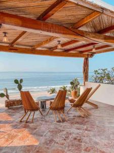 two chairs on a patio with a view of the beach at Casa Conti Agua Blanca in Playa Agua Blanca