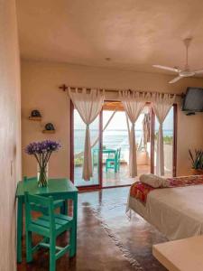 Casa Conti Agua Blanca في Playa Agua Blanca: غرفة نوم بسرير وطاولة عليها ورد