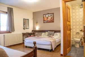 a bedroom with a bed and a bathroom at Maison Ostaria MyHolidayLivigno in Livigno +250 photos
