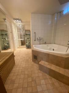 La grande salle de bains est pourvue d'une baignoire et d'une douche. dans l'établissement Stockholm-Arlanda privat rum i rymlig villa gratis wifi 1Gb fiber parkering Room1, à Täby