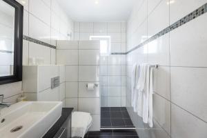 bagno bianco con lavandino e servizi igienici di Palm Crest a Willemstad