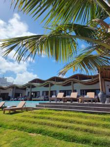ein Resort mit einem Pool und einer Palme in der Unterkunft Filho do Vento Kite & Lodge in Canguaretama