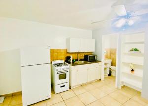 a kitchen with a stove and a white refrigerator at Hallandale Beach Motel in Hallandale Beach