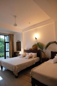 1 dormitorio con 2 camas y ventana en MIRISSA Reef Serenity en Mirissa