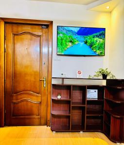 a room with a door and a television on the wall at Altheda Living Eroilor 116-A4 in Suceava +11 photos