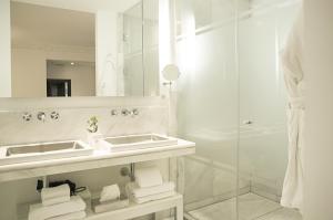 a bathroom with two sinks and a shower at Hospes Puerta de Alcalá, a Member of Design Hotels in Madrid
