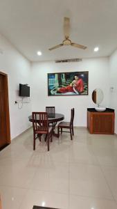 a room with a table and chairs and a painting on the wall at The Star Resorts in Vagamon