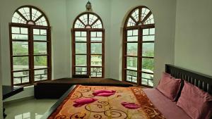 a bedroom with windows and a bed with a bedspread at The Star Resorts in Vagamon