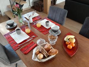 uma mesa com comida para o pequeno almoço e sumo de laranja em Le Refuge du Hibou em Beaurains